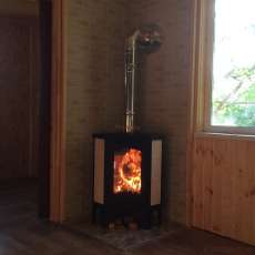 Стальной камин с большим стеклом Бавария угловая Амазонка бай фото в интерьере в Минске