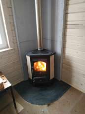 Недорогая печь-камин со стеклом Бавария угловая с плитой фото в интерьере в Минске